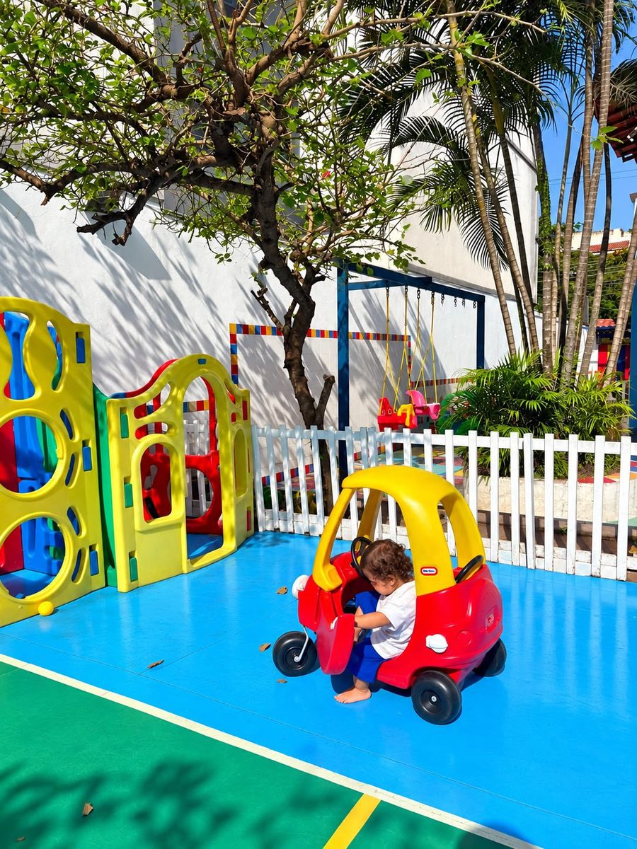 Criança brincando no carrinho do parquinho ao ar livre