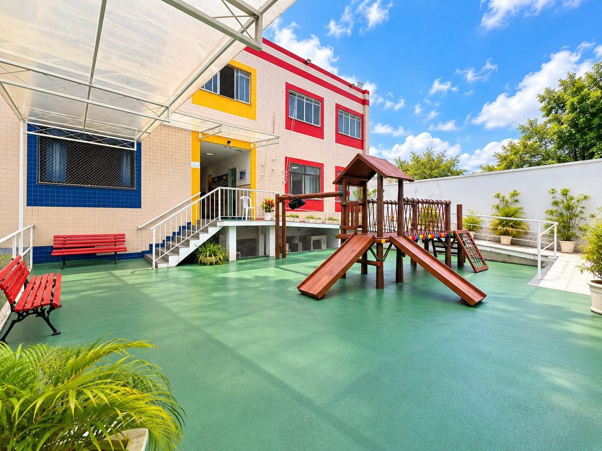 Pátio externo do Colégio Recreio com parquinho e piso verde
